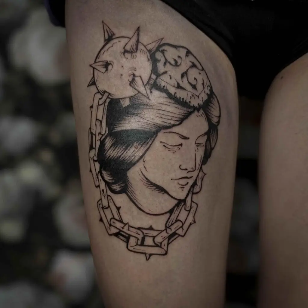 tatouage d'un visage sur un cuisse de terrenoire
